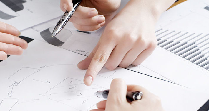 Das Bild zeigt gestikulierende Hände über Vorbereitungen für eine Personalabrechnung bei Herrmann Steuerberatung. 