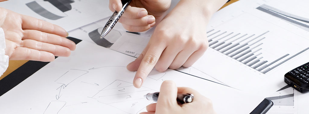 Das Bild zeigt gestikulierende Hände über Vorbereitungen für eine Personalabrechnung bei Herrmann Steuerberatung.